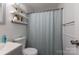 Bathroom with gray vanity, shower/tub, and floating shelves at 1520 Yellowstone Ct, Gastonia, NC 28054