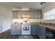 Gray kitchen cabinets, white appliances, and laminate floor at 1520 Yellowstone Ct, Gastonia, NC 28054