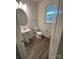 Powder room featuring a pedestal sink and a window, with hardwood flooring at 3018 Cunningham Farm Dr, Indian Trail, NC 28079