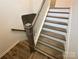 Staircase with wood treads, white risers, and dark wood handrail, leading to the upper level at 3018 Cunningham Farm Dr, Indian Trail, NC 28079