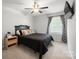 Nicely appointed bedroom with a comfortable bed, ceiling fan, and modern dark accents at 3020 Pinehills Way, Mount Holly, NC 28120