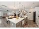 Open kitchen and dining area with stainless steel sink, island with seating, and view to the living room at 3020 Pinehills Way, Mount Holly, NC 28120