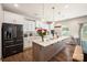 Bright kitchen features white cabinets, stainless steel appliances, and a large center island with pendant lighting at 3020 Pinehills Way, Mount Holly, NC 28120