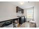 Functional laundry room with modern washer and dryer, ample countertop space, and dark cabinets at 3020 Pinehills Way, Mount Holly, NC 28120