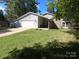 Ranch style home with gray siding, attached garage, and a spacious lawn at 6001 Long Pine Dr, Charlotte, NC 28227