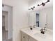 Bathroom featuring a double sink vanity, large mirror, modern lighting, and a doorway at 10132 Whitaker Pointe Dr, Huntersville, NC 28078