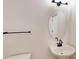 Modern half bathroom with a pedestal sink, oval mirror, and sleek lighting at 10132 Whitaker Pointe Dr, Huntersville, NC 28078