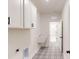 Bright laundry room with patterned tile floor, sink, and white cabinets at 10132 Whitaker Pointe Dr, Huntersville, NC 28078