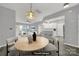 Virtually staged dining area with a wood table and kitchen view at 14307 San Paolo Ln # 5102, Charlotte, NC 28277