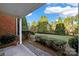 Brick building exterior with a small patio, lush green landscaping, and a tree-lined background at 14307 San Paolo Ln # 5102, Charlotte, NC 28277
