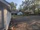 Gravel backyard with a large shed and surrounding trees with natural light at 131 Glendale Se Ave, Concord, NC 28025