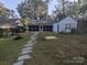 Lush backyard with stone walkway leading to a screened-in porch, perfect for outdoor relaxation at 131 Glendale Se Ave, Concord, NC 28025