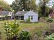 View of the backyard and exterior of the home with a screened-in porch and lush garden area at 131 Glendale Se Ave, Concord, NC 28025