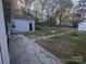 Wide backyard featuring a stone patio, outbuildings, and lush greenery, ideal for outdoor living at 131 Glendale Se Ave, Concord, NC 28025