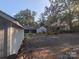 Gravel backyard with a large shed and surrounding trees with natural light at 131 Glendale Se Ave, Concord, NC 28025