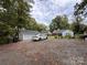 Backyard with a gravel driveway, shed, well-maintained lawn, and mature trees offering ample shade at 131 Glendale Se Ave, Concord, NC 28025