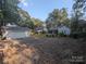 Gravel backyard with a large shed and surrounding trees with natural light at 131 Glendale Se Ave, Concord, NC 28025