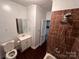 Modern bathroom featuring brown tiled shower, toilet, sink, and mirror at 131 Glendale Se Ave, Concord, NC 28025