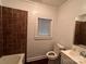 Bathroom featuring a window, toilet, sink and vanity, with a brown tiled shower at 131 Glendale Se Ave, Concord, NC 28025