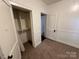 Bedroom featuring carpeted floors, white walls, closet, and two doors at 131 Glendale Se Ave, Concord, NC 28025