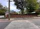 Street view of the neighborhood featuring a red brick wall with greenery and mature trees at 131 Glendale Se Ave, Concord, NC 28025