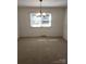 Bright and empty room with neutral carpet and a modern light fixture at 3111 Sandy Porter Rd, Charlotte, NC 28273