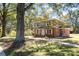 Two-story brick home with landscaped yard and mature trees shading a long sidewalk at 3111 Sandy Porter Rd, Charlotte, NC 28273