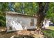 Side of a white house needing renovation, showing brick foundation and large tree at 3444 Marvin Rd, Charlotte, NC 28211