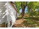 Side of a white house needing renovation, showing brick foundation and yard at 3444 Marvin Rd, Charlotte, NC 28211