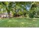 Charming white house with a spacious front yard surrounded by lush trees at 3444 Marvin Rd, Charlotte, NC 28211