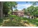 Expansive backyard with a pool, lush lawn, and privacy fence, with brick home in background at 1134 Willow Oaks Trl, Matthews, NC 28104