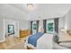 Inviting bedroom featuring a wooden bed, a striking light fixture, and natural light through windows at 1134 Willow Oaks Trl, Matthews, NC 28104