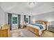 Sunlit bedroom featuring hardwood floors, a wood bed, and large windows with lush green views at 1134 Willow Oaks Trl, Matthews, NC 28104