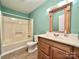 Well-lit bathroom features a tub and shower combination, tile floor, and a wood vanity at 125 Pineville Rd, Statesville, NC 28677