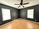 Bright bedroom featuring wood floors, ceiling fan, and natural light from windows at 125 Pineville Rd, Statesville, NC 28677