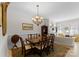 Formal dining room with chandelier, wooden table, and view to living room at 155 Harper Lee St, Davidson, NC 28036