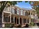 Brick townhome with front porch and American flag; beautiful landscaping at 155 Harper Lee St, Davidson, NC 28036