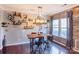 Lighted dining area with rustic wall and wooden table with four chairs at 7324 Friar Tuck Ln, Mint Hill, NC 28227