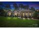 Beautiful brick home with landscaping, illuminated at night at 115 Hawk Run Ln, Troutman, NC 28166