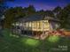 Brick home with sunroom and deck, illuminated at night at 115 Hawk Run Ln, Troutman, NC 28166