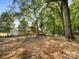 Large private backyard with a wooden deck, mature trees, and an old-fashioned rope tree swing at 13079 Philadelphia Church Rd, Oakboro, NC 28129