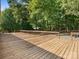 Spacious wooden back deck offering an outdoor living space surrounded by mature trees at 13079 Philadelphia Church Rd, Oakboro, NC 28129