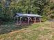 Aerial view of metal roofed barn nestled in a green field at 13079 Philadelphia Church Rd, Oakboro, NC 28129