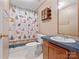 Cozy bathroom featuring a shower with patterned curtain, a wooden shelving unit and a vanity at 13079 Philadelphia Church Rd, Oakboro, NC 28129