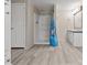 Bathroom featuring a white stand-up shower with blue shower curtain, a vanity and wood-look flooring at 13079 Philadelphia Church Rd, Oakboro, NC 28129