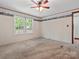 Bedroom with neutral carpeting, paneled walls and two windows allowing for lots of natural light at 13079 Philadelphia Church Rd, Oakboro, NC 28129