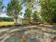 Exterior view of a single-story home with a green metal roof, and a gravel driveway at 13079 Philadelphia Church Rd, Oakboro, NC 28129