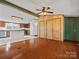 Living room offers views of the kitchen and features wood wall accents and hardwood floors at 13079 Philadelphia Church Rd, Oakboro, NC 28129