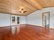 Spacious living room featuring hardwood floors, wood ceiling, and access to the deck at 13079 Philadelphia Church Rd, Oakboro, NC 28129