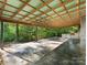 Large concrete patio with exposed ceiling beams and wooded views at 13079 Philadelphia Church Rd, Oakboro, NC 28129